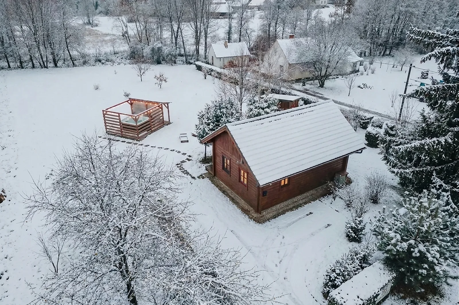 A Kiskunyhó és a jakuzzis pergola télen, havas kertben, drónnal fotózva