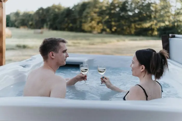 Egy pár koccint a kerti jakuzziban