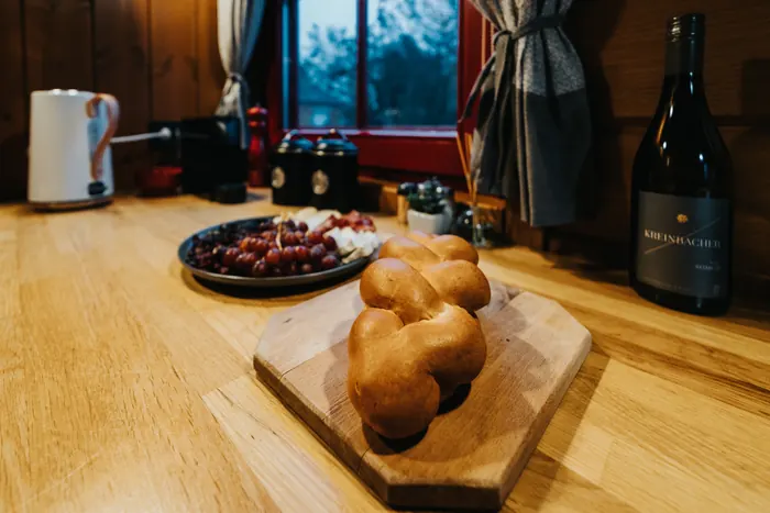 Fonott kalács vágódeszkán és egy üveg bor a konyhapulton
