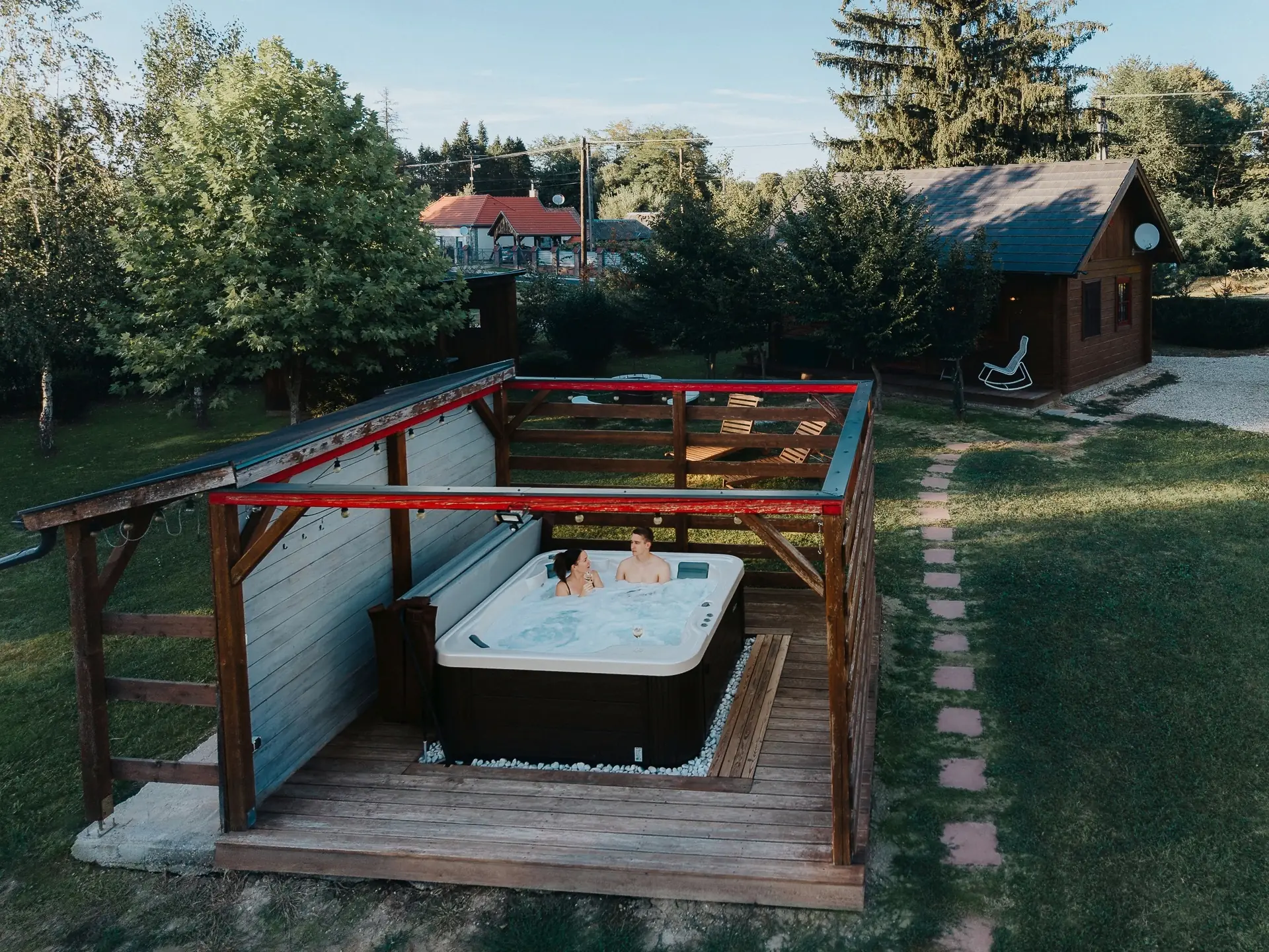 A Kiskunyhó kerti jakuzzija a pergola alatt és a gerendaház, drónnal fotózva